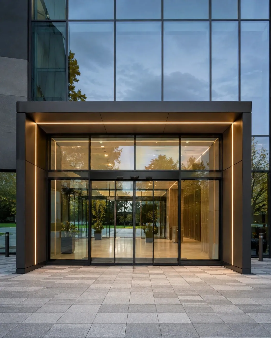 Illuminated automatic sliding glass entrance at a modern office building
